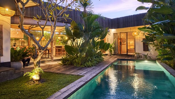A modern house with a swimming pool, surrounded by lush greenery and a wooden deck. - Tropical Designer Private Villa, 3br, Umalas (Kerobokan)