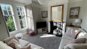 A living room with a fireplace, a television, and a sofa. - Castle Cottage in Conwy - 2 minute walk into Conwy yet has delightful garden (Conwy)