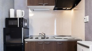A modern kitchen with a built-in microwave, coffee maker, and refrigerator. - Tofukuji Riverside (Kyoto)