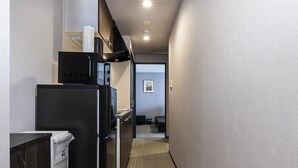 A narrow hallway with a refrigerator, microwave, and a trash bin. - Tofukuji Riverside (Kyoto)