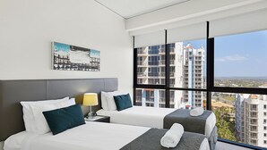A hotel room with two beds, a view of high-rise buildings, and a painting on the wall. - Hinterland Views 2BR apartment - Sierra Grand - CoastHM (Broadbeach)