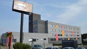 Un edificio de hotel moderno con un cartel llamativo que anuncia una estación de radio.