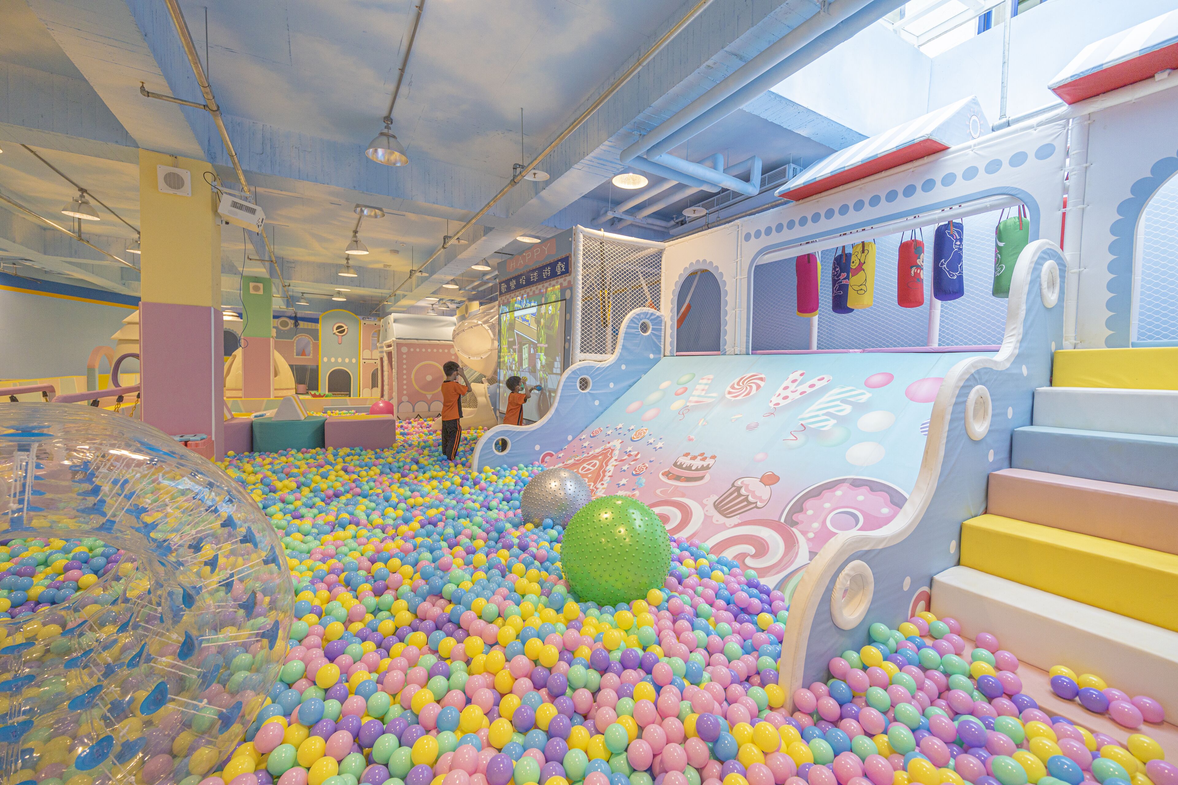 An indoor play area with colorful balls, a slide, and a ball pit.