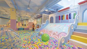 An indoor play area with colorful balls, a slide, and a ball pit.