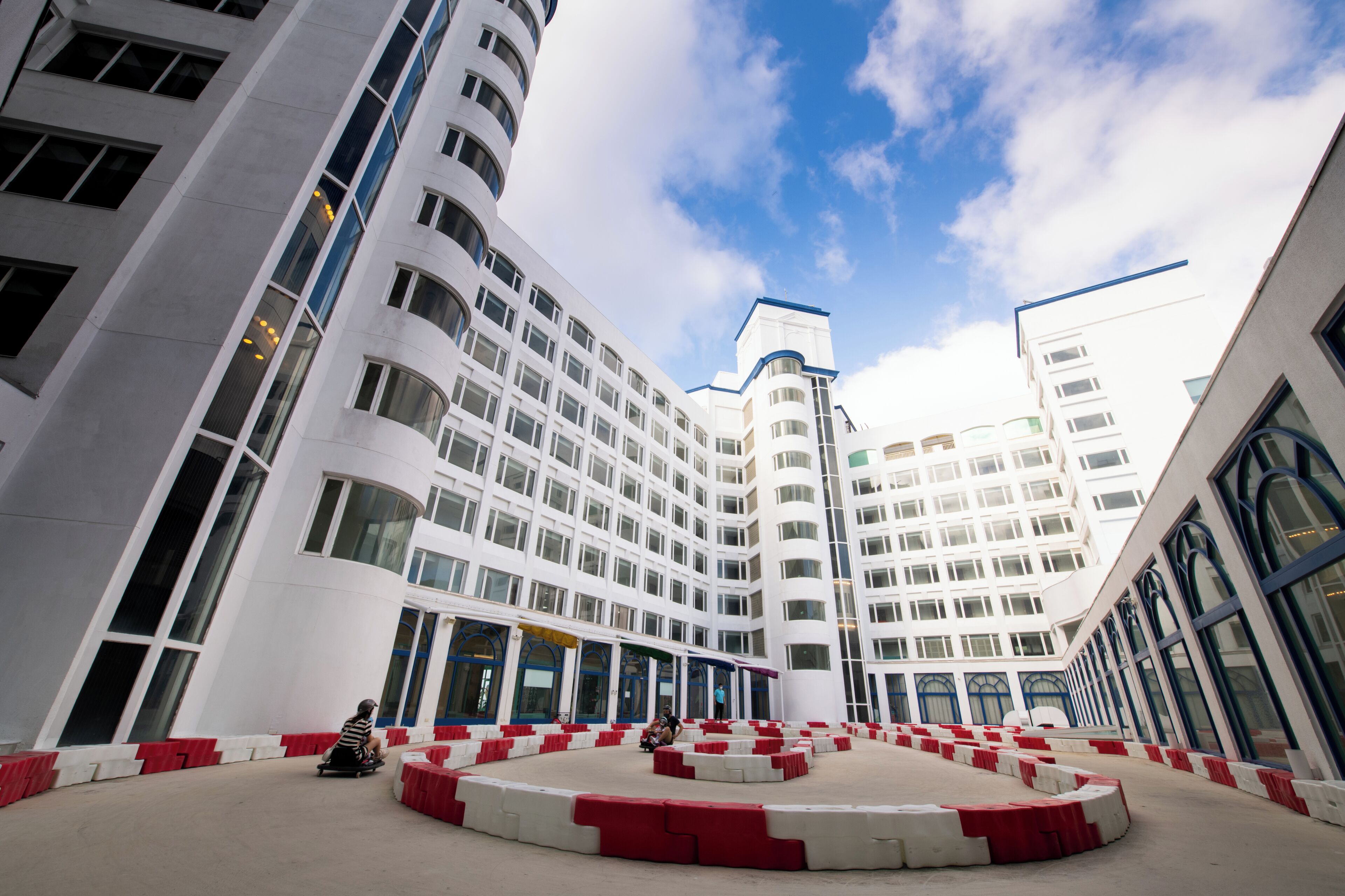 A modern building with a central courtyard, large windows, and a clear sky.