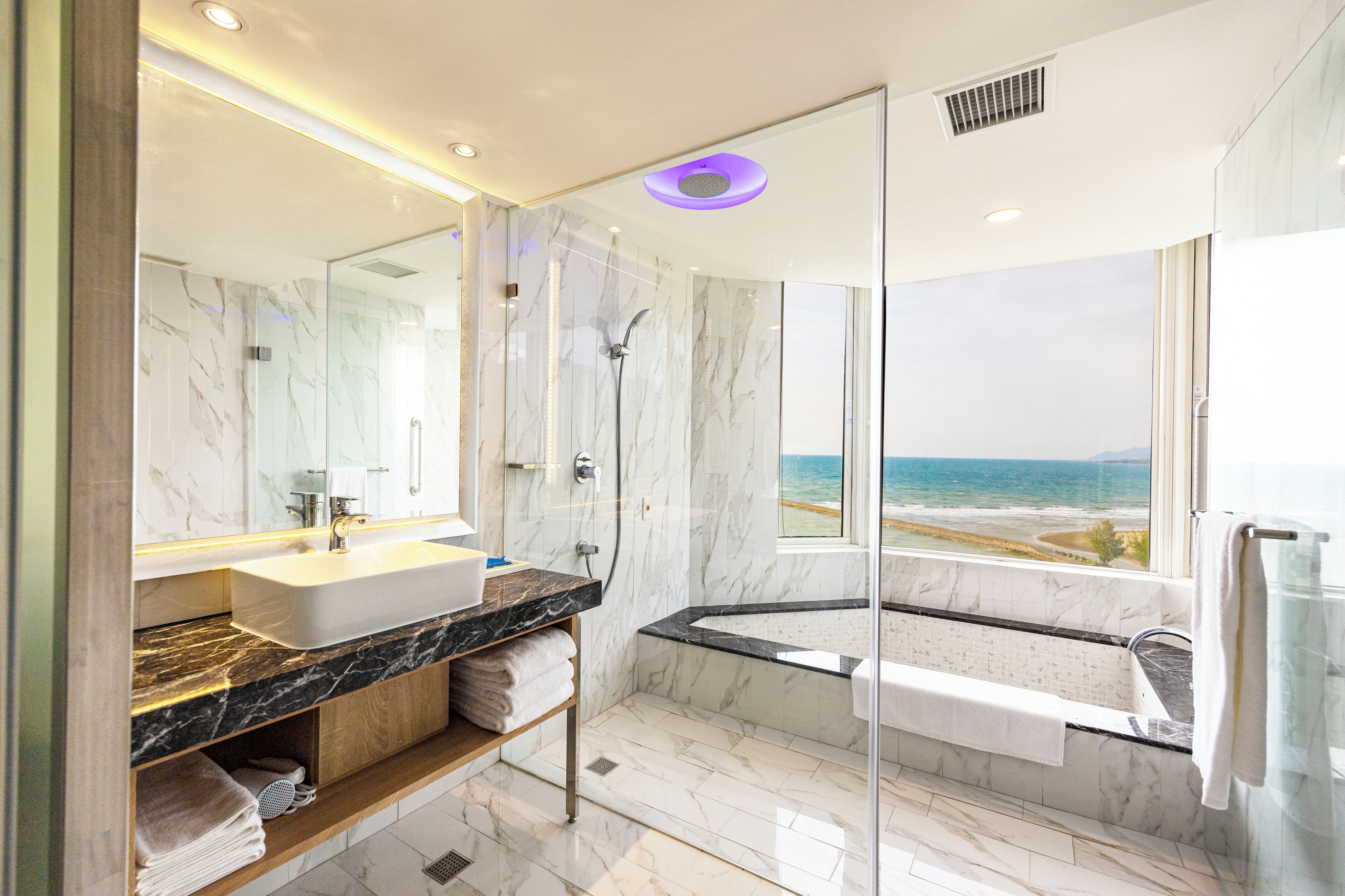Ein modernes Badezimmer mit großem Spiegel, Waschbecken, Badewanne und Dusche.