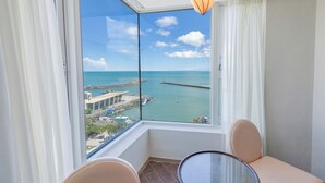 A balcony with a view of the sea, a table, and chairs. - Kenting Long Beach Hotel (Checheng)