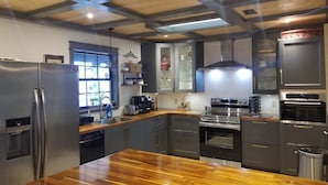 Eine moderne Küche mit einer Holztheke, Edelstahlgeräten und einer gewölbten Decke.