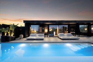 A modern outdoor pool area with lounge chairs and a wooden deck. - Unique Design 4 Bedrooms: Casa del Sol, Estepona (Estepona)