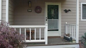 Le numéro 26 sur la maison, une porte d’entrée, une guirlande et une décoration représentant un oiseau.