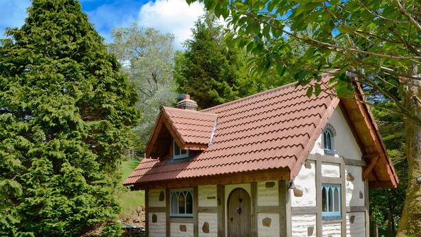 Une maison traditionnelle avec un toit en tuiles, des murs en pierre et un chemin en pierre menant à l’entrée.