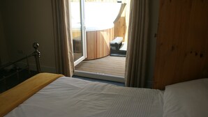 Une chambre à coucher avec un lit, une fenêtre et une vue sur une terrasse extérieure.