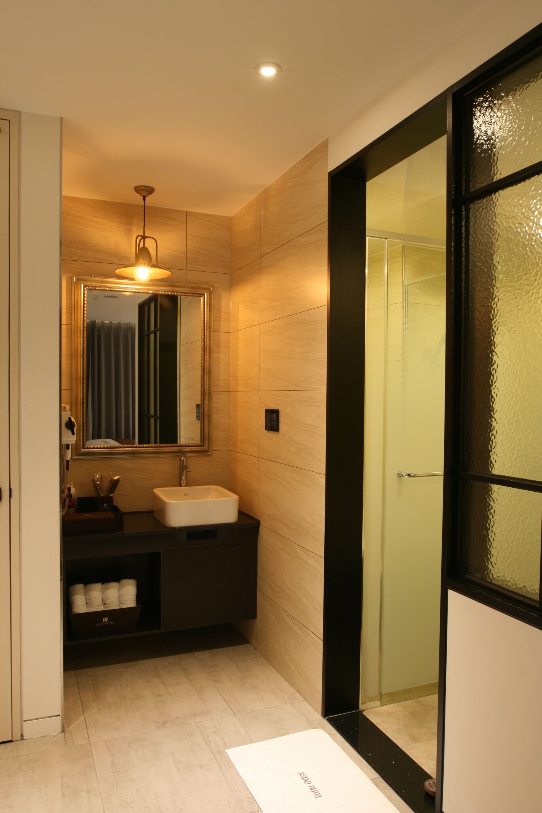 A modern bathroom with a large mirror, a sink, and a glass shower enclosure.