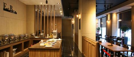 A modern restaurant with a long counter, wooden paneling, and a marble floor.