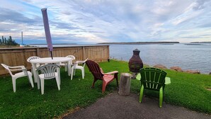 A patio with a table and chairs overlooking a lake. - Cabin on the clouds. (Cocagne)