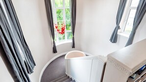 Un escalier avec une rampe blanche et un mur incurvé.