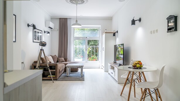 Un salon moderne comprenant un canapé, une table basse et un coin repas avec une table et des chaises.