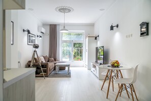 Una sala moderna con un sofá, una mesa de centro y una zona de comedor con una mesa y sillas.