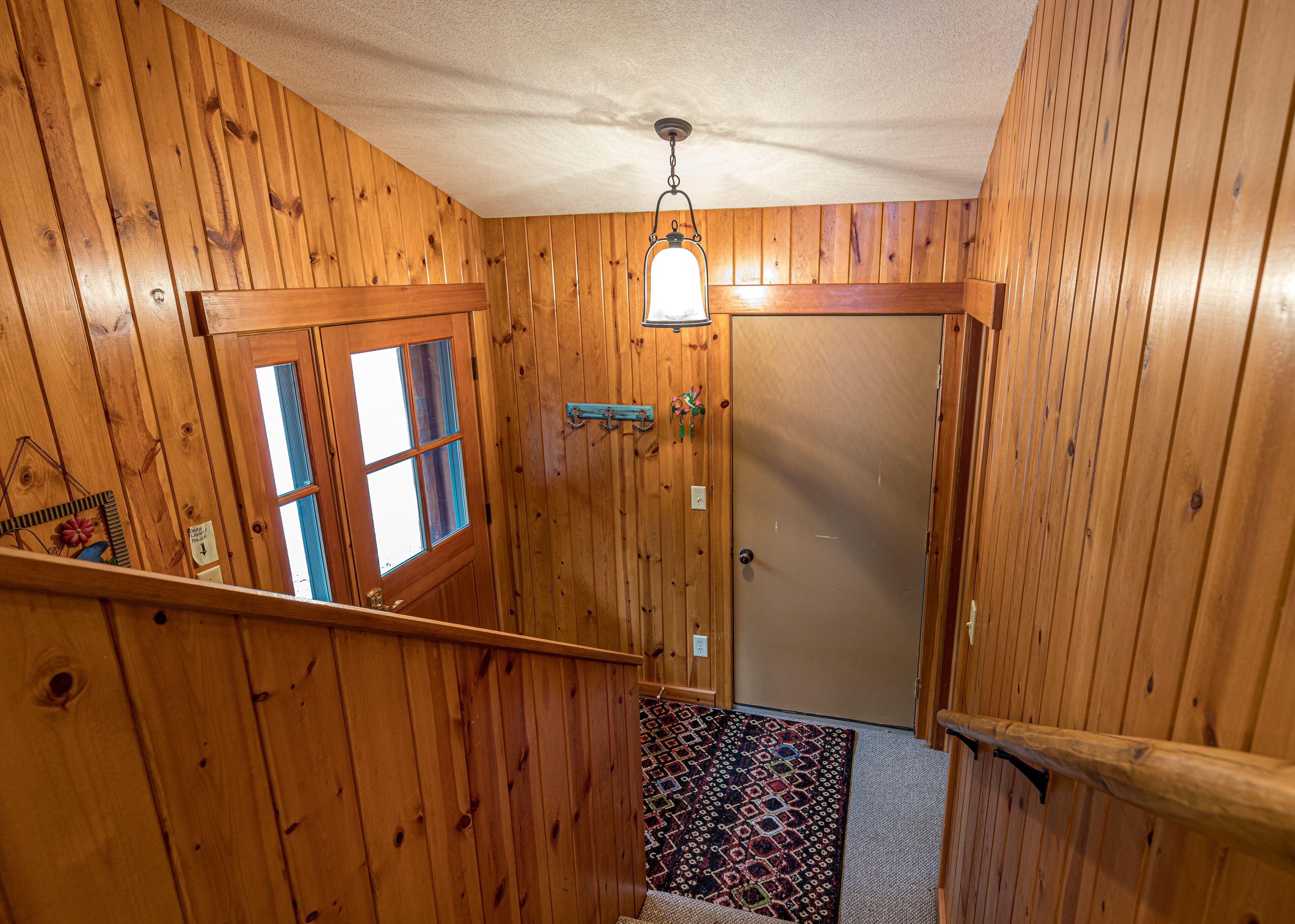 Un interno in legno con una scala che conduce a una porta.