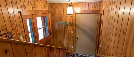 Un interno in legno con una scala che conduce a una porta.