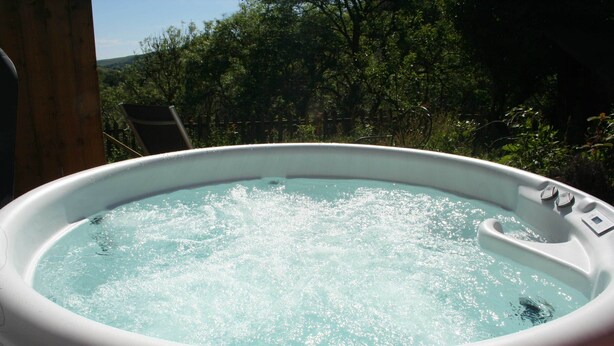A hot tub with a wooden deck and a view of trees. - The Nook - Farm Park Stay with Hot Tub, BBQ & Fire Pit (Swansea)