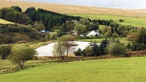 A rural landscape with a pond, trees, and houses. - The Nook - Farm Park Stay with Hot Tub, BBQ & Fire Pit (Swansea)
