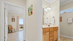 Une salle de bain avec un grand miroir, des meubles en bois et une fenêtre.