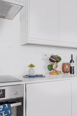 Enjoy cooking in this well-equipped kitchen with a stainless steel range hood, oven, and dishwasher.