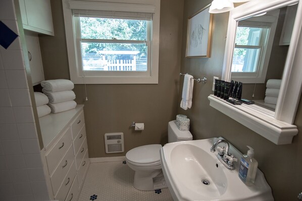 Une salle de bain avec des toilettes, un lavabo et une fenêtre.