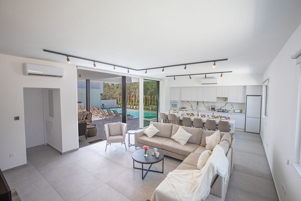 A modern open-plan living area with a sofa, coffee table, and dining table.