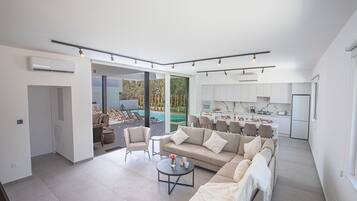 A modern open-plan living area with a sofa, coffee table, and dining table.