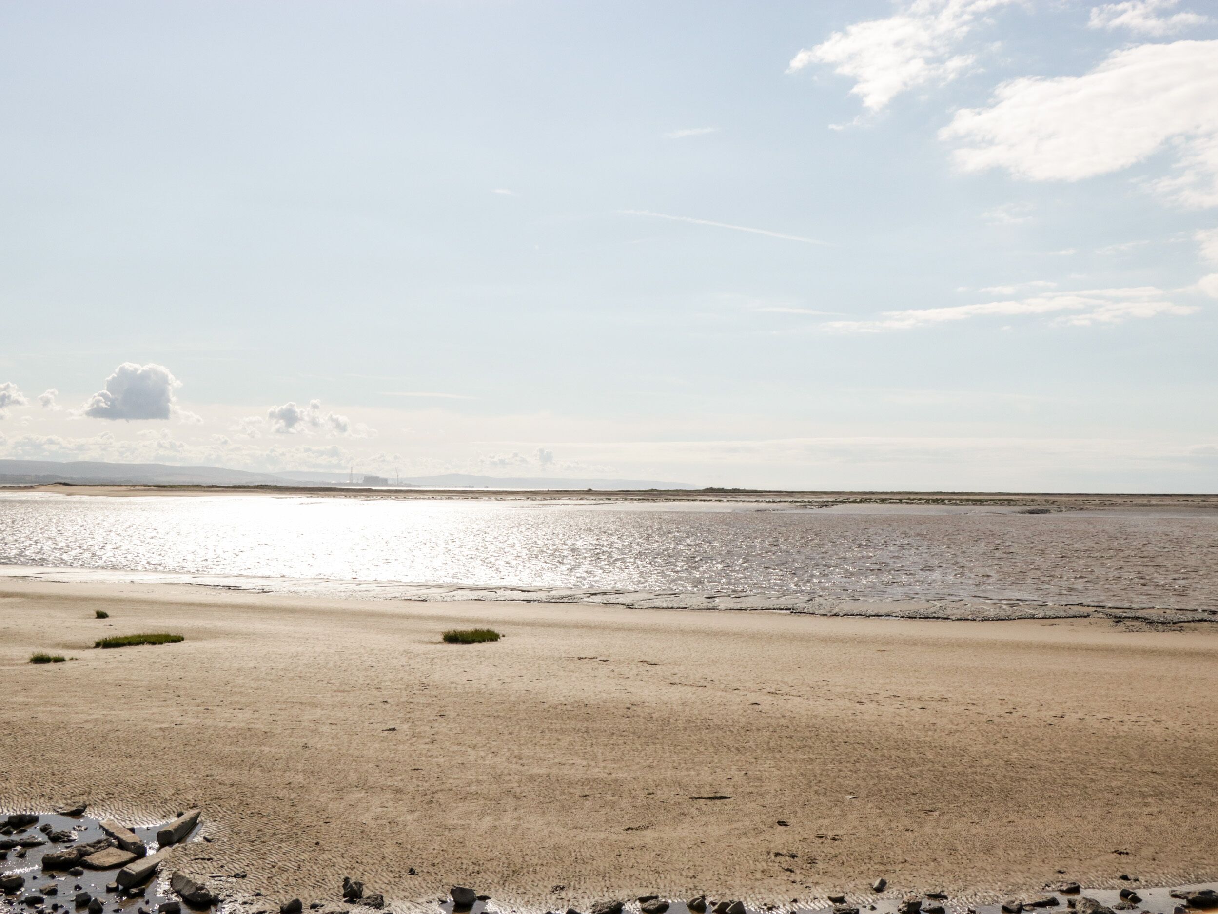 A beach with a sandy shore and calm water.