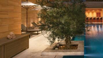 Relax by the serene pool surrounded by lush greenery and comfortable seating.
