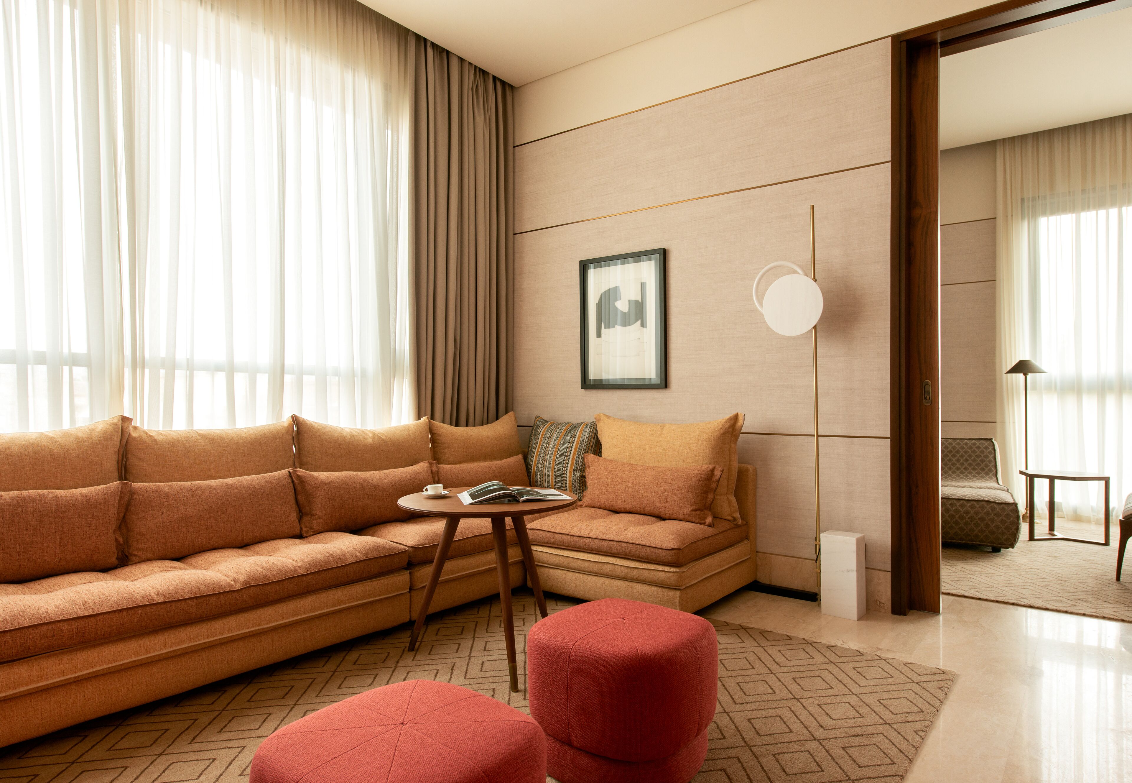 Una sala moderna con un conjunto de sofá, un reposapiés y una mesita con un libro.