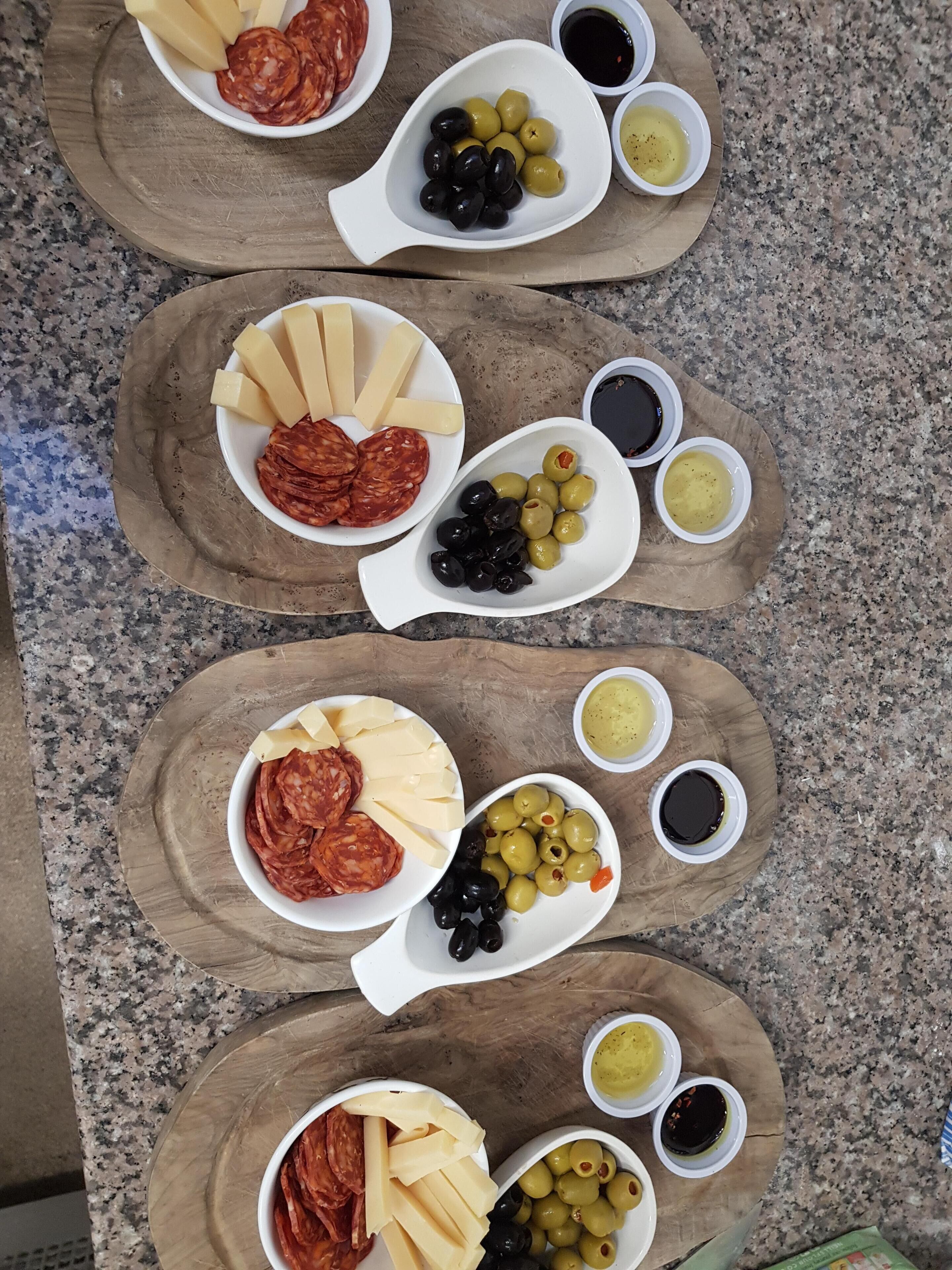 Una taula amb diferents aliments, com ara formatges, olives i salses.