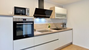 A modern kitchen with a built-in oven, microwave, and stainless steel sink.