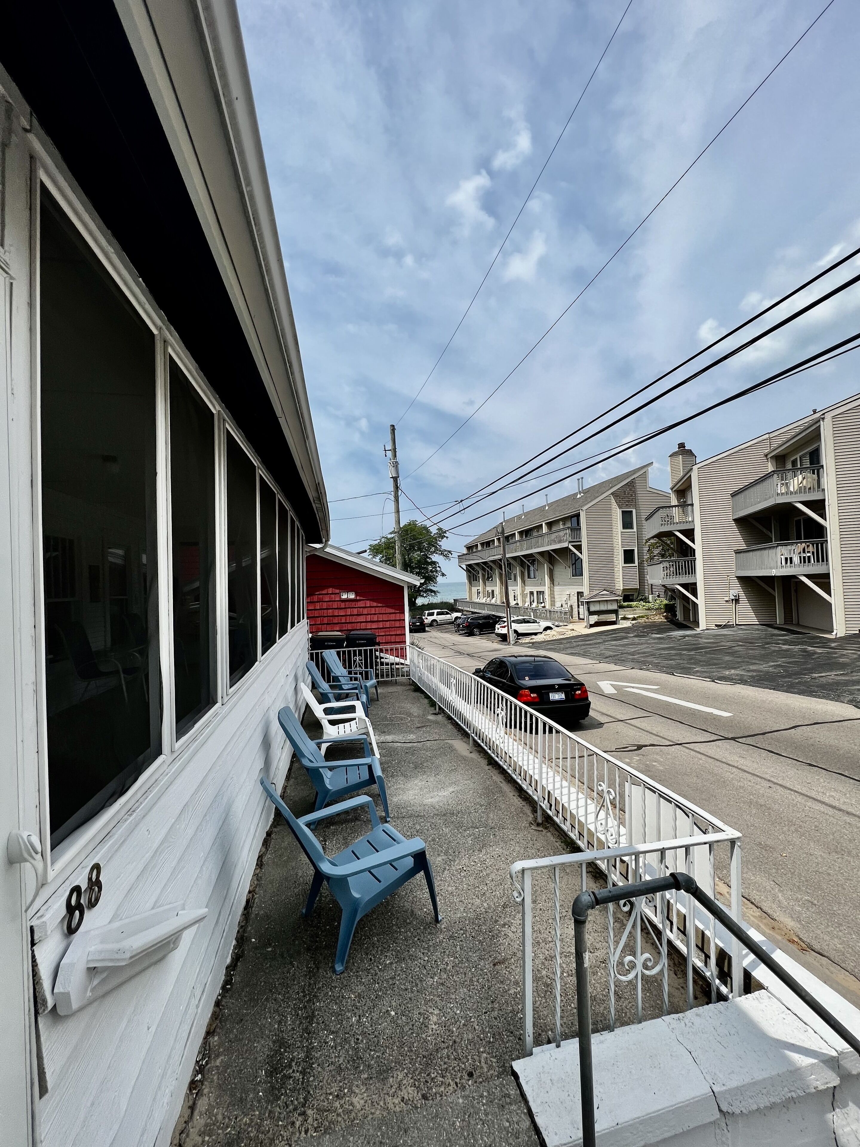 A building with a red awning, outdoor seating, and a street view.