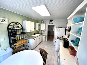 Compact kitchen with sink, coffee maker, and refrigerator, offering a convenient space for meal preparation.
