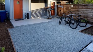 A modern two-story house with a garage, a wooden deck, and a bicycle parked outside. - lower west side style & quality 1BR (Santa Cruz)