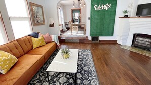 Un salon avec un canapé marron, une table basse blanche et un mur vert sur lequel est écrit le mot « Wichita ».