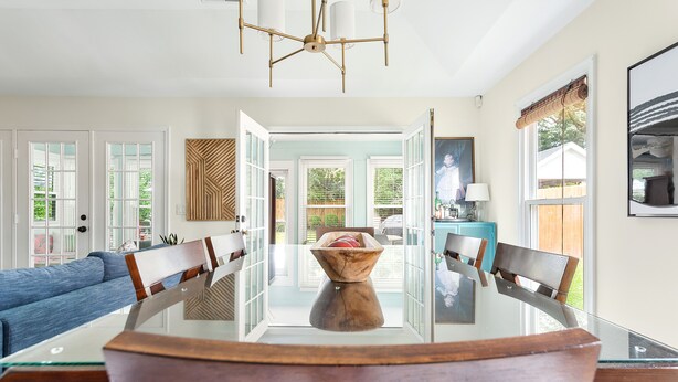 A dining area with a glass table, wooden chairs, and a central decorative bowl. - Fenced In Backyard! | The Fox Pond (Mount Pleasant)