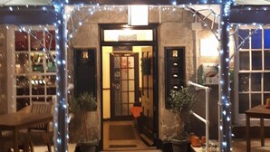 The exterior of The Crown Inn with a marquee sign, a checkered entrance, and potted plants. - Crown Inn (Penzance)
