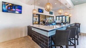A bar area with a counter, bar stools, and pendant lighting. - Perfect Location, Beautiful and Spacious 8BD Home, Free Waterpark! #8so884 (Kissimmee)