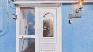 A white door with frosted glass panels, a small window, and a blue wall with a '1 SEAVIEW' sign.