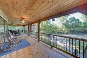 A wooden deck with a view of a river, outdoor furniture, and a ceiling fan. - Mt River House Retreat Star5vacations (Ellijay)