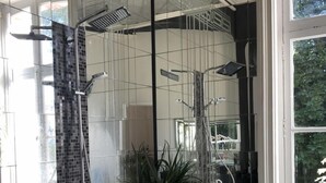 Un baño moderno con un espejo grande, una bañera y zona de ducha.