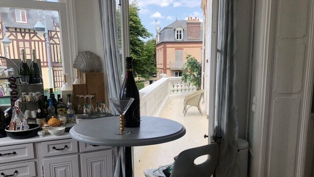 Habitación con una mesa de comedor, sillas, una pequeña cocina y vistas al exterior.