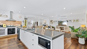 A modern kitchen with a central island, built-in oven, and dishwasher.