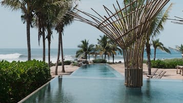 Una piscina al aire libre, sombrillas, tumbonas