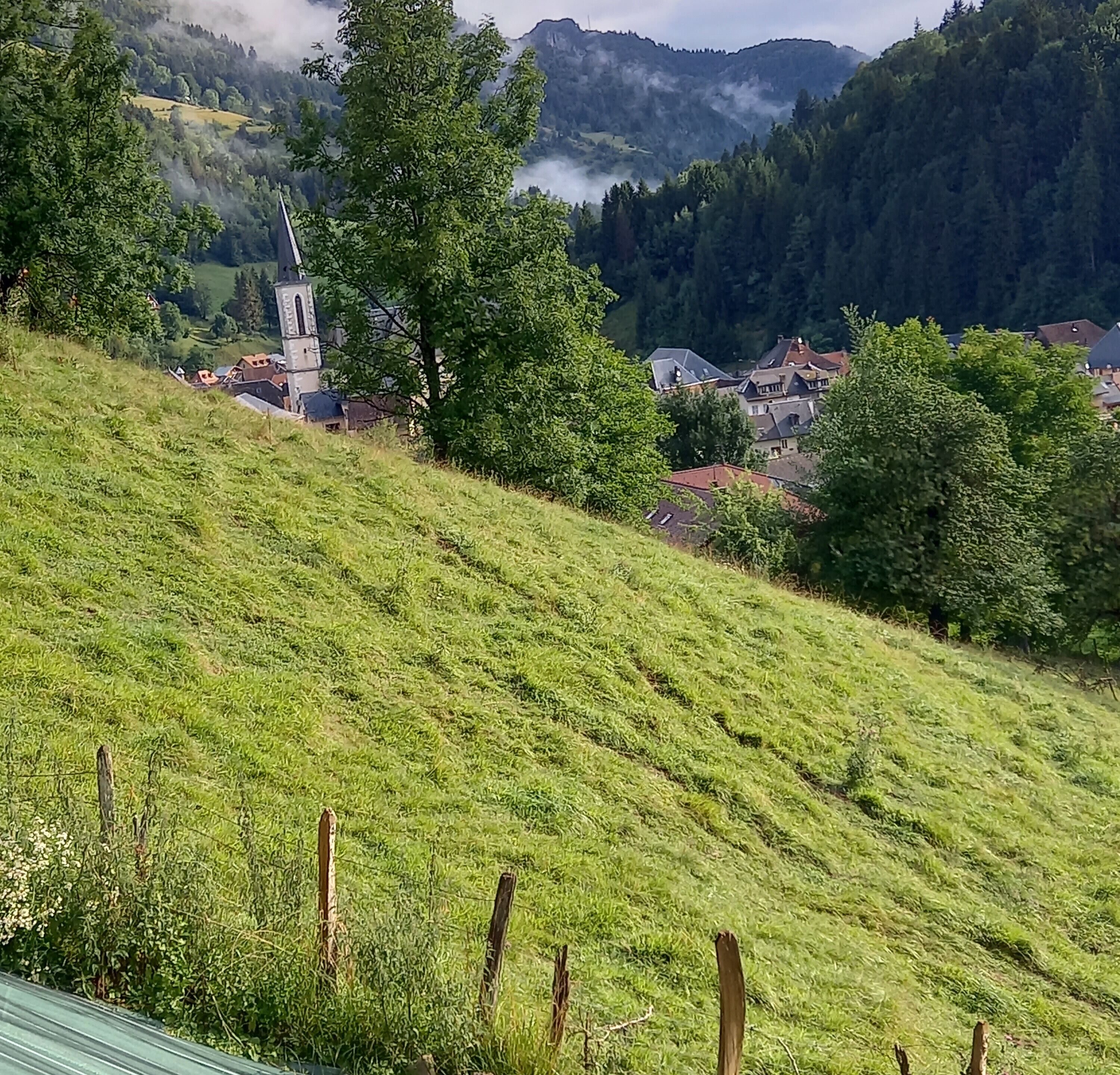 Un paysage rural avec une église, des maisons et une colline.
